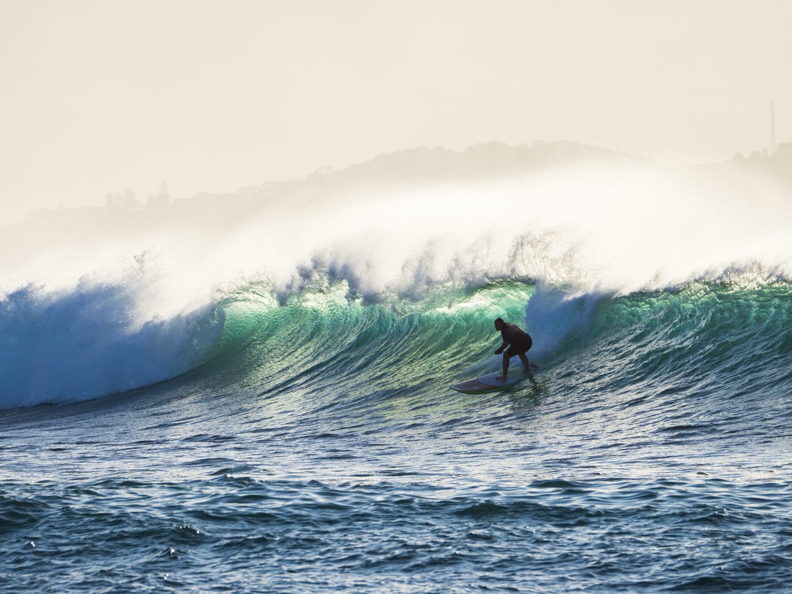 Silhouette of a man surfing in the wavy sea - perfect for background